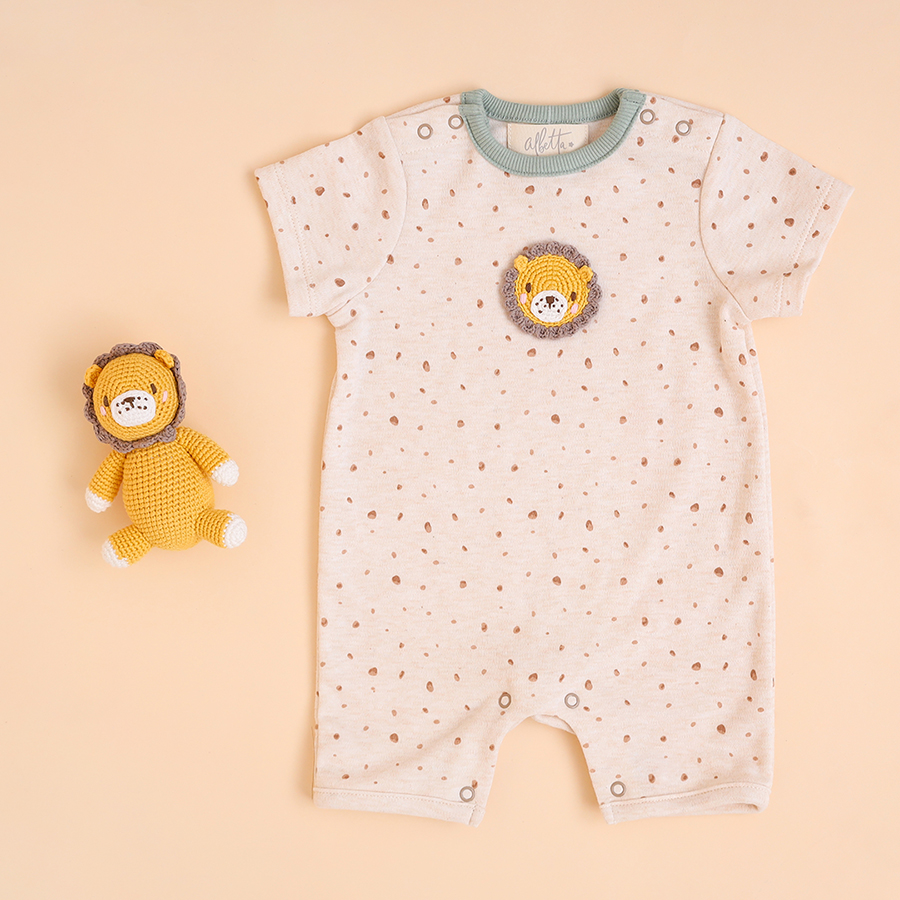 Soft cream baby romper with grey neckline trim, showcasing a crochet lion design with a mane and closed eyes.